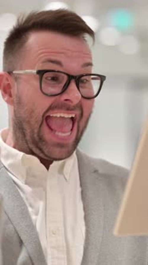 Man Expresses Excitement While Using Tablet Device Indoors