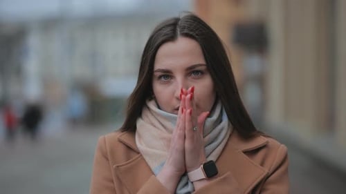Fashionable Brunette Warming Hands in the City