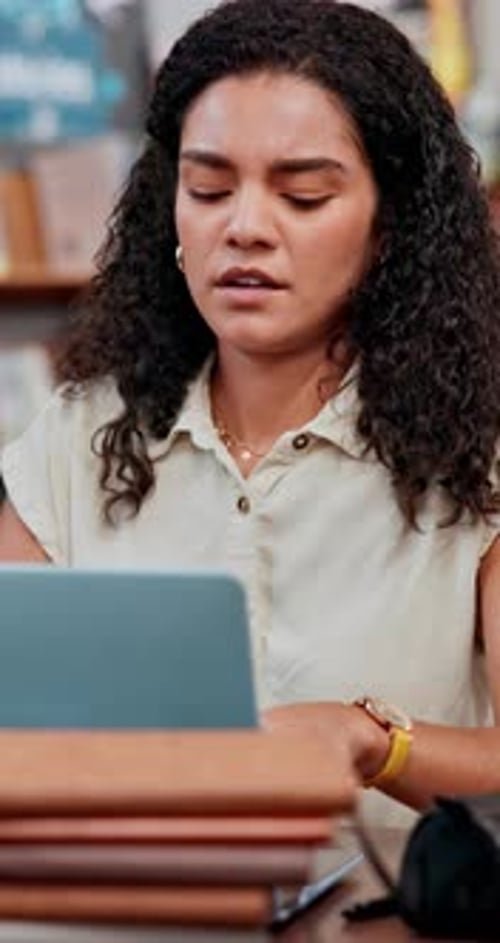 Woman, student and headache in library with laptop, stress and frustrated for exam