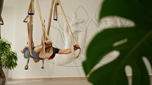 Man Doing Aerial Yoga Poses in Studio