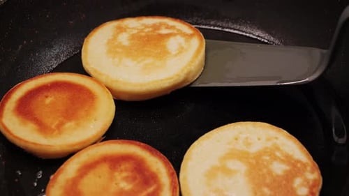 Pancakes Cooking in a Pan with Oil