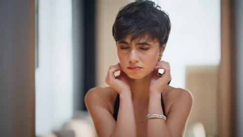 Beautiful Woman Posing with Hands on Face Indoors