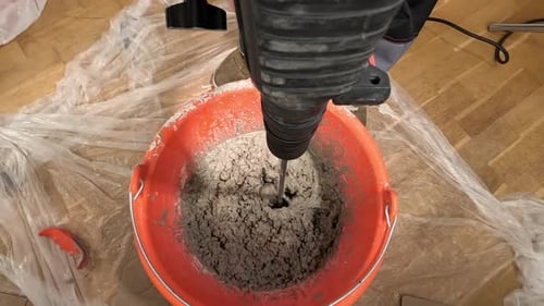 Mixing Gray Mortar in a Red Bucket