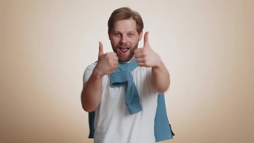 Happy Young Man Raises Thumbs Up Agrees or Gives Positive Reply Recommends Advertisement Likes Good