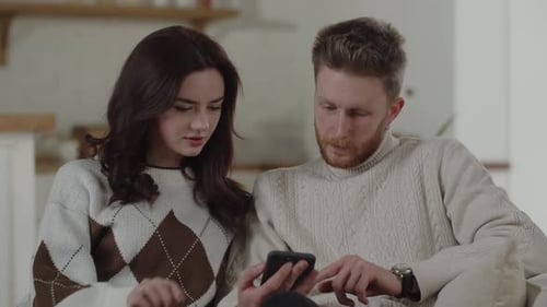 Couple Relaxing Indoors Using Mobile Phone Together