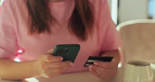 Young Woman Holding Credit Card and Smartphone at Home Female Shopper Using Easy Mobile Payments