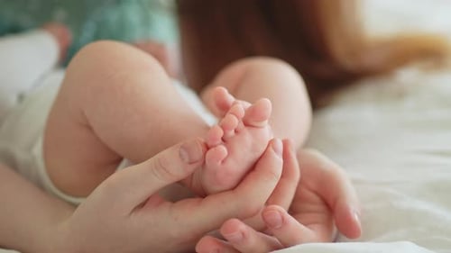 Infant's Feet Held Gently in Loving Hands