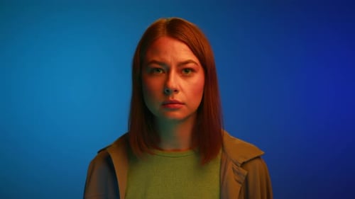 Stern Young Woman Glaring Under Blue Lighting