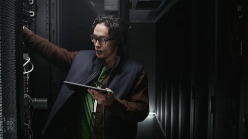 Network Technician Checking Server Connections in Data Center