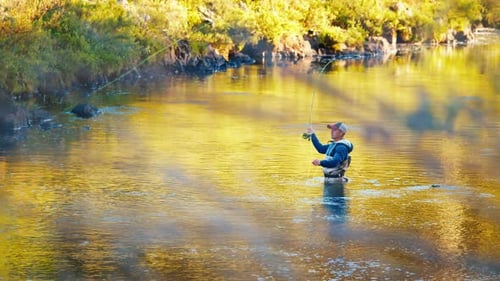 Fisherman Casts the Line on a River at Sunrise