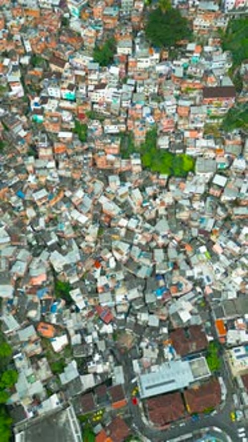 Vista aérea de habitações densamente povoadas no Rio de Janeiro, mostrando uma favela com uma mistura vibrante de