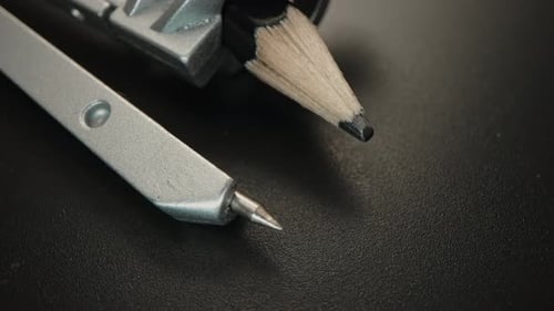 Close-Up of Drafting Compass and Pencil on Dark Background