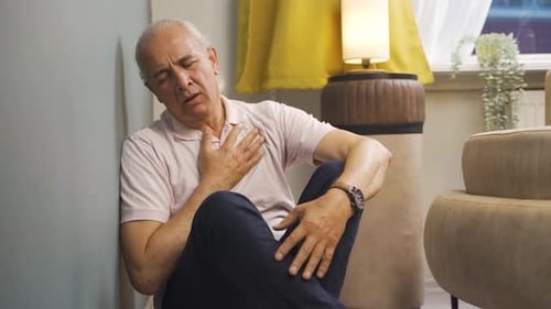 Sick old man coughing leaning against wall. Hopeless.