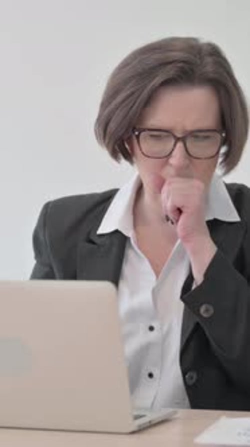 Woman Coughing While Working on Laptop at Desk
