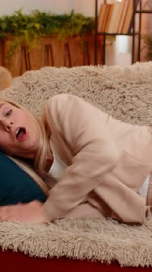 Woman practices breathing exercises on a fluffy couch