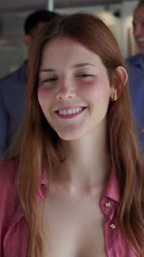 Confident Young Businesswoman Standing in Modern Office with Team Behind Her