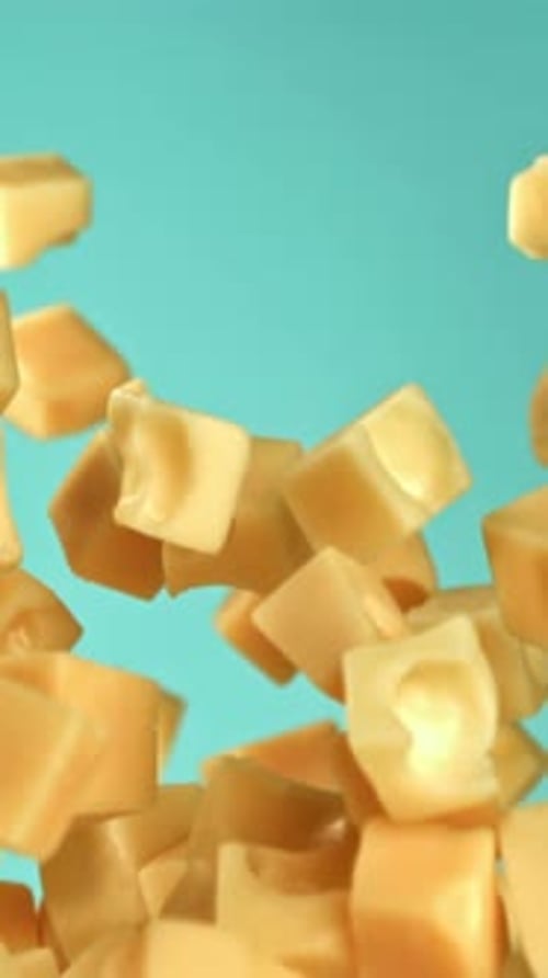 Pieces of Maasdam Cheese Fly Upwards on a Blue Background Filmed on a Highspeed Camera at 1000 Fps