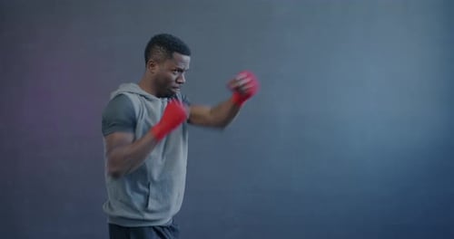 Man Practicing Boxing Punches With Red Hand Wraps
