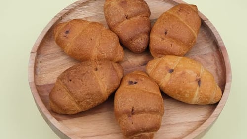 Fresh Golden Brown Croissants on a Wooden Plate