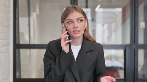 Woman in Blazer Talking on Her Mobile Phone