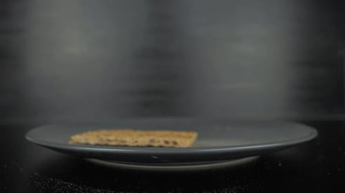 stack of rye crisbread falling on grey plate,close-up