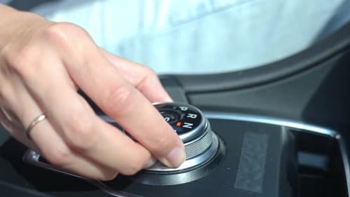 Hand Shifting Gears with Rotating Dial in Car