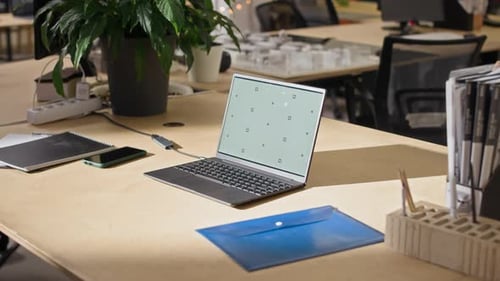 Laptop on Desk in Modern Office Workspace with Notebooks and Phone