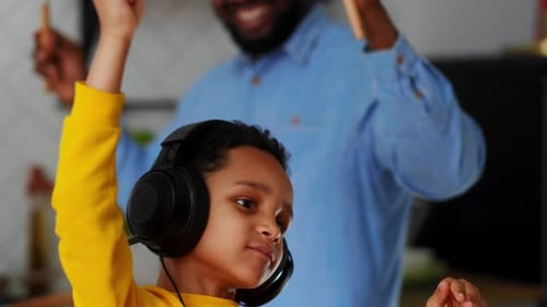 Child Listening to Music and Dancing with Adult