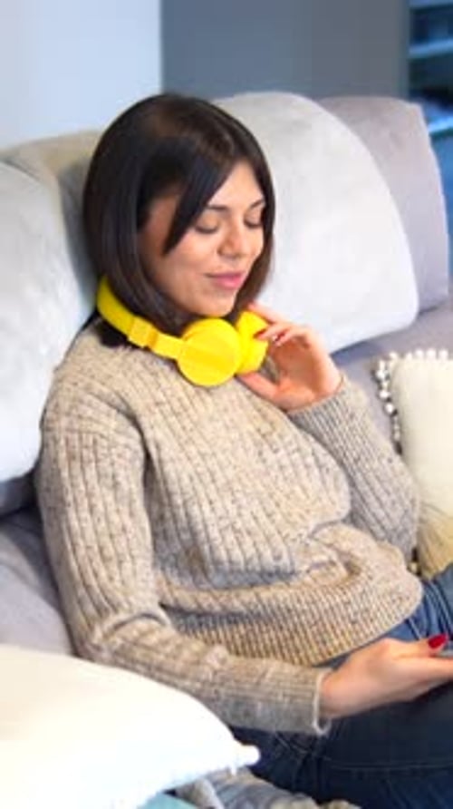 Woman Putting on Headphones at Home