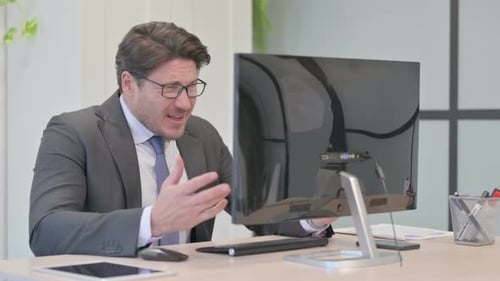 Young Businessman Reacting to Loss While Working on Computer