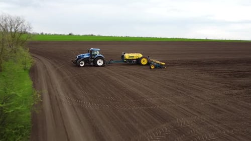 Blue tractor OA working on the field in Ukraine