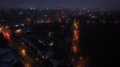 Aerial orbit wide shot of small american town at foggy dusk. Lighting lantern on street and driving
