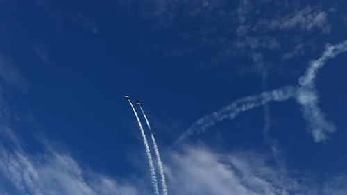 Planes Performing Acrobatics Leaving White Smoke Against Blue Sky