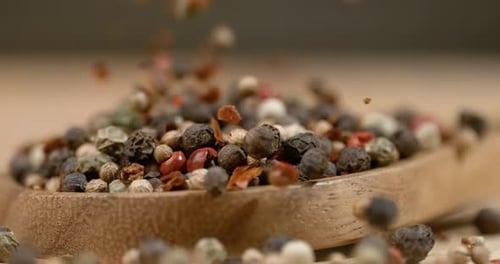 Mixed peppercorns in a super slow motion. Dry mix peppercorns close up.
