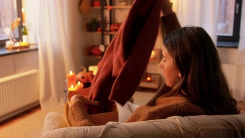 Halloween-Urlaubs- und Freizeitkonzept - Junge Frau nimmt Wollpullover von
