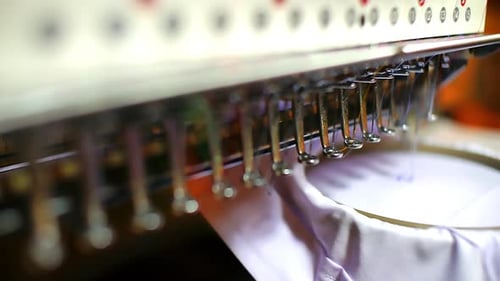 Closeup view of an automated embroidery working on a textile design, stitching a pattern onto a shir