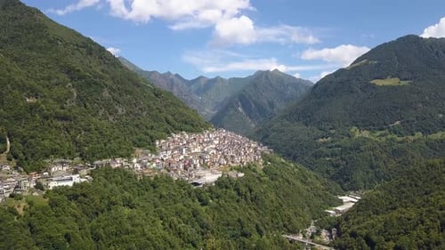 Aerial of a beautiful small village on a lush green mountain, Premana, Italia