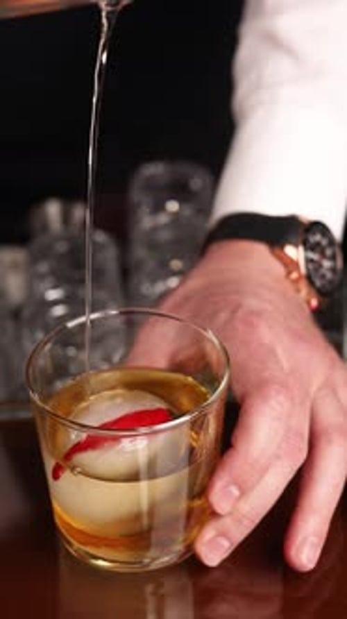 the bartender prepares a popular cocktail at the bar