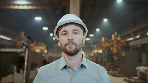 Portrait of Industrial Engineer in Safety Helmet at Work in Factory