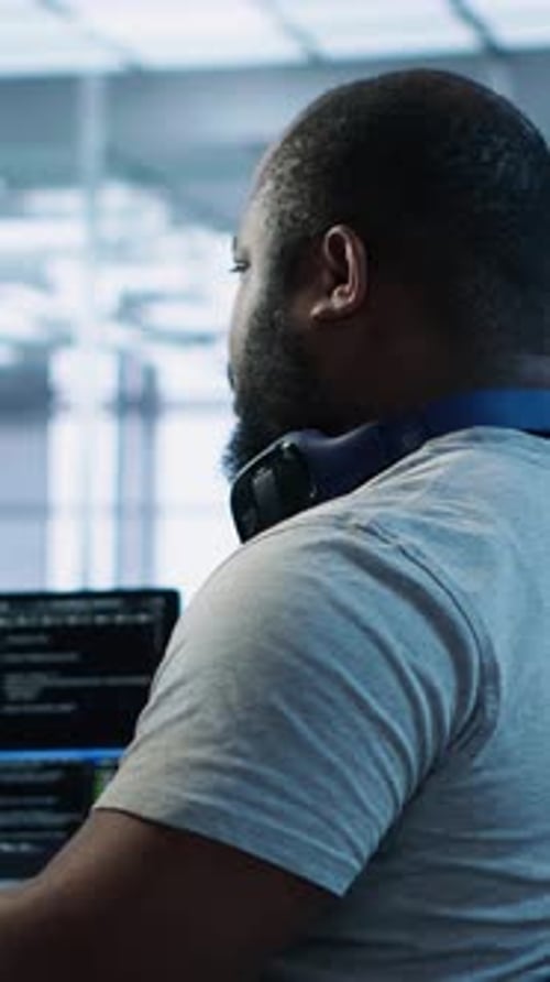 Glücklicher Ingenieur, der über den Witz eines Kollegen lacht, während er in einer High-Tech-KI-Einrichtung arbeitet