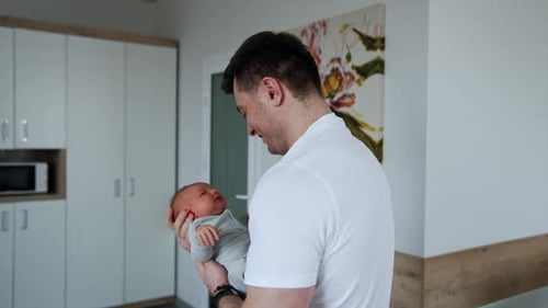 Loving Father Holds Newborn Baby Indoors
