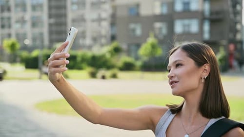 Young Beautiful Woman Having Video Call Chat on Smartphone Outdoor City Background