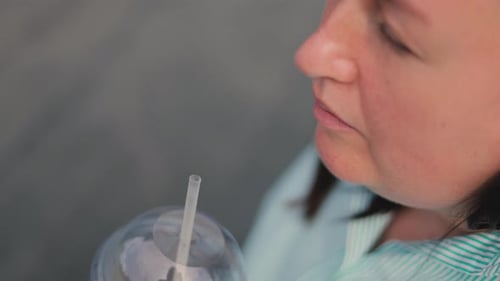 Adult Sipping Drink with Straw Close Up