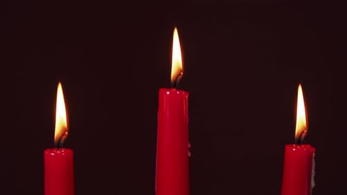 Burning Red Candles in a Dark Room
