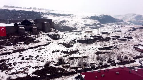 High Angle Aerial Shot of Snowy Hillside Neighborhoods and Red Roofed Buildings in Kars