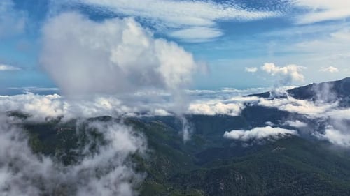 Majestic mountain landscape with clouds rolling over at midday