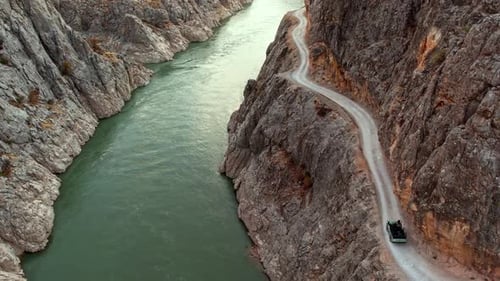 Jeep Driving on Winding Cliffside Road Carved Into Rocky Walls in Kemaliye Canyon