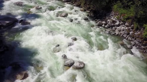 River Current Flowing in the Valley Around the Smooth Rocks During a Bright Sunny Spring Day