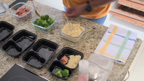 Homme plaçant quatre boîtes à repas pour les déjeuners, ramassant les céréales, ajoutant des protéines et du brocoli, espace de copie