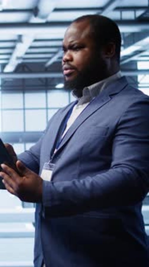 Operador de Vídeo Vertical usa dispositivo digital no data center, garantindo que as plataformas estejam funcionando